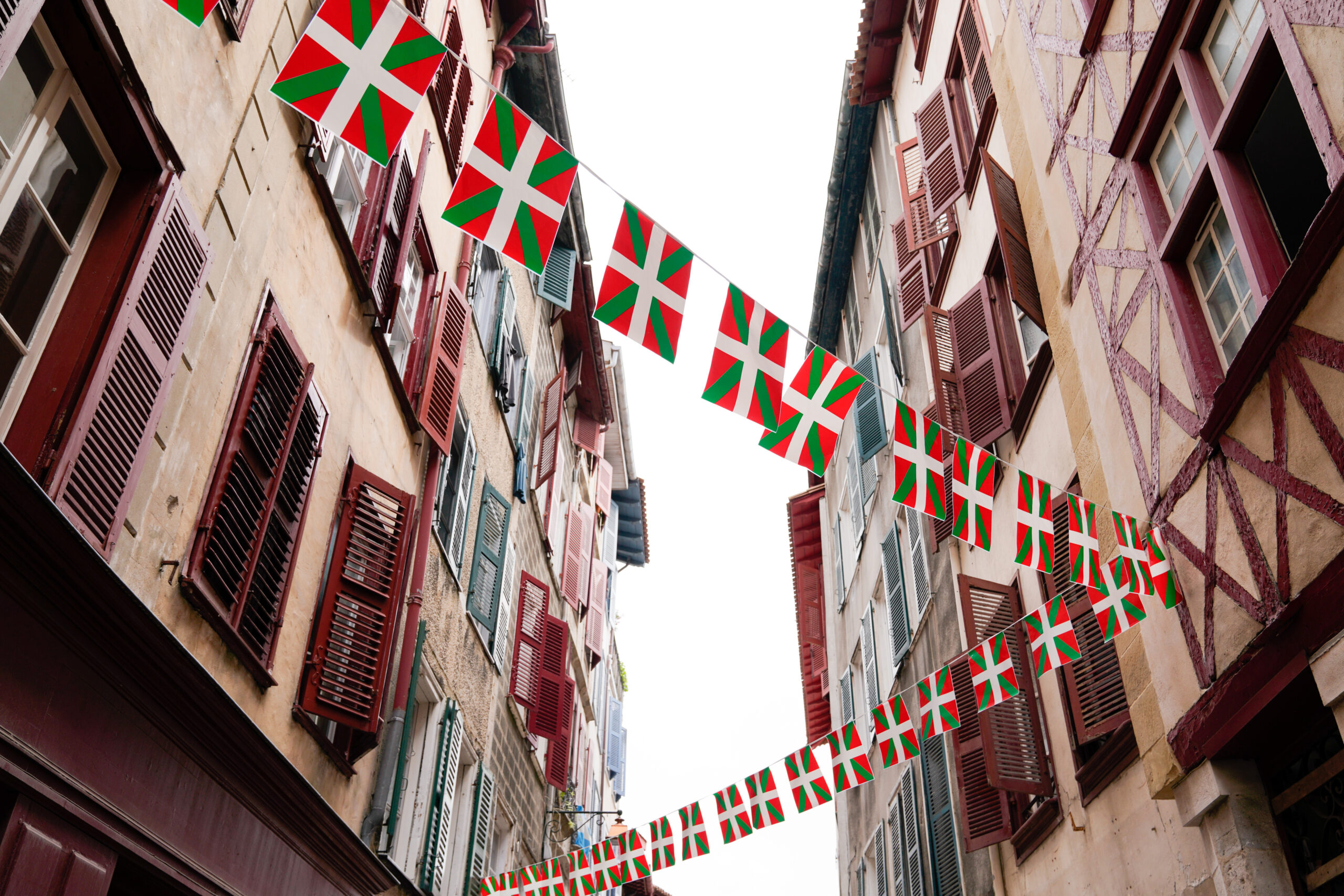 bask flag on facades of old houses basque in Bayonne France barkery bliss café biarritz